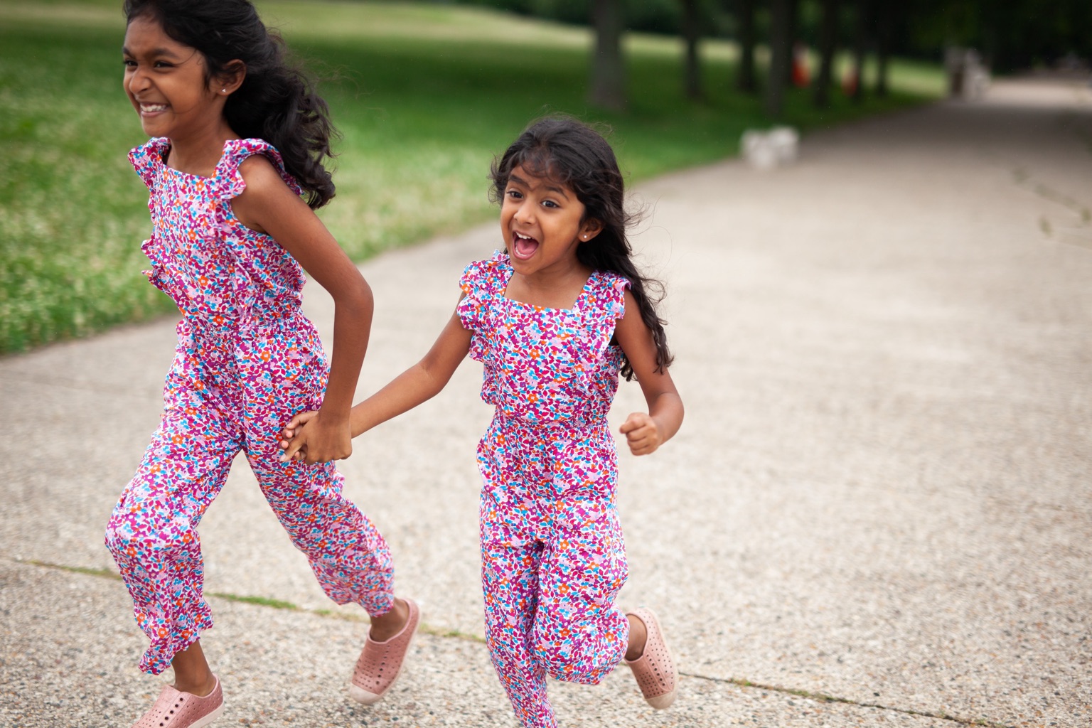 Two sisters holding hands and running